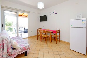 Cozy living space with a comfortable bed, dining area, and flat-screen TV.