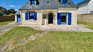 Ein zweistöckiges Haus mit einer Steinaußenwand, einem Satteldach und einer kleinen Veranda.