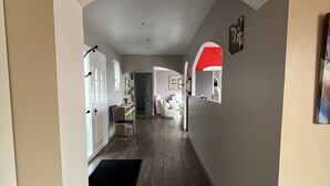 Un pasillo con una zona de cocina, una mesa de comedor y un arco rojo.