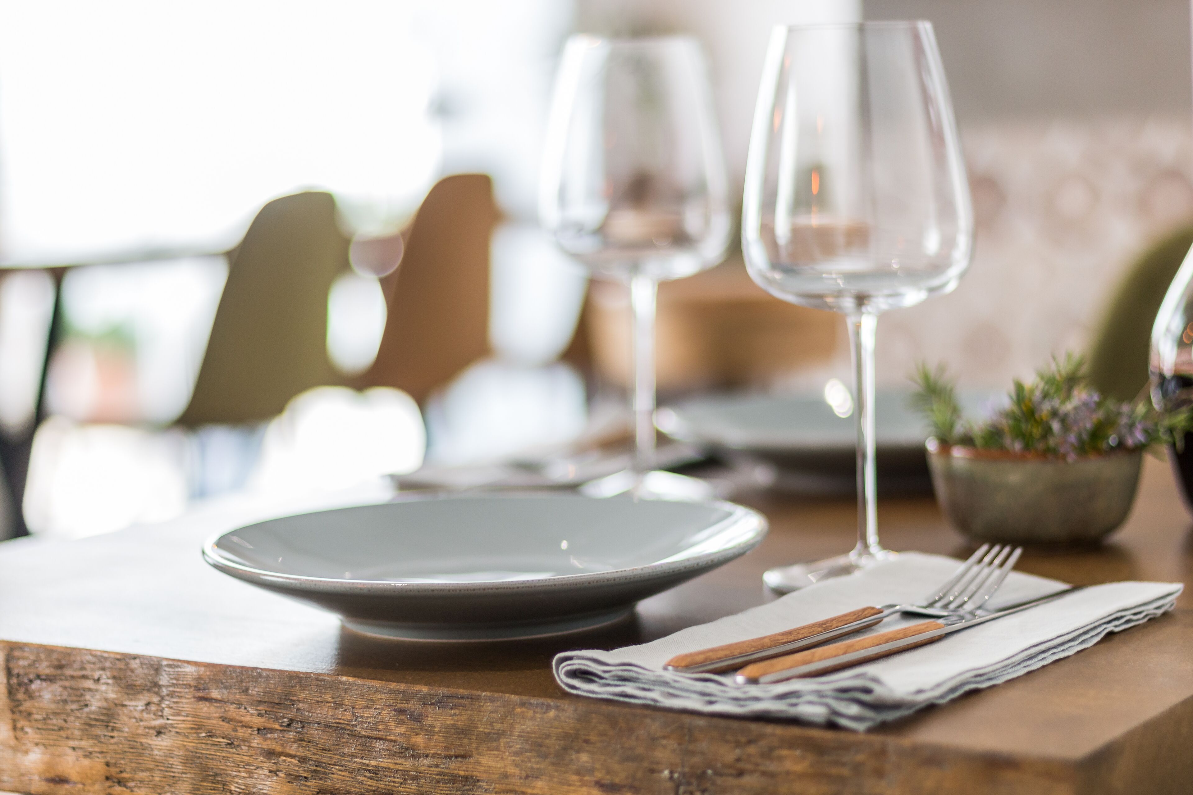 A dining table with a plate, cutlery, and a glass.