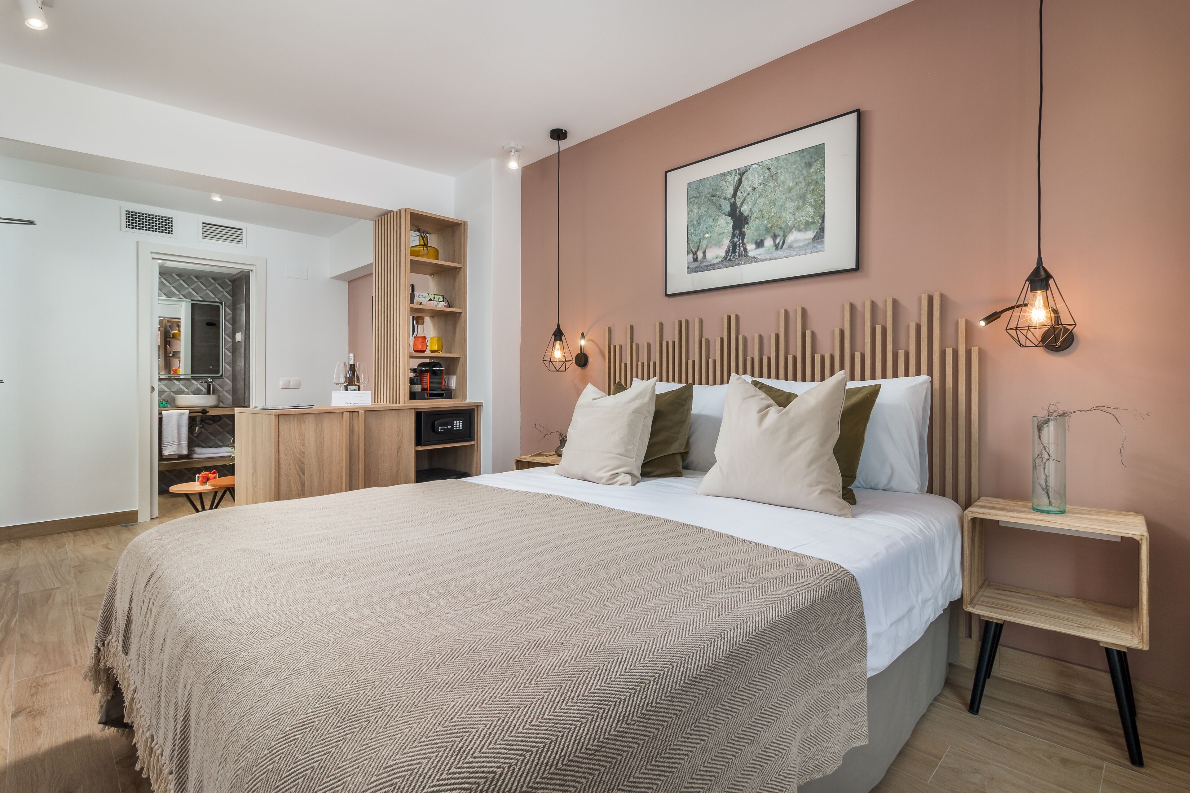 A modern bedroom with a large bed, a wooden headboard, bedside tables, and a wardrobe.