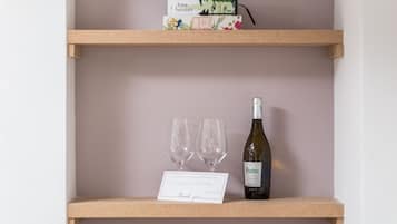 A wooden shelf with a wine bottle and two glasses, a thank you card, and a box labeled "tree houses".