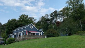 A house with a covered porch and a fenced yard. - Cozy cottage with a hot tub on the bay of fundy (Berwick)