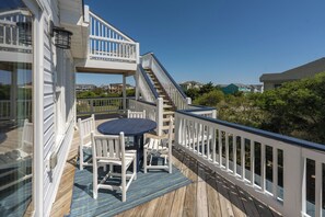 A wooden deck with a table and chairs, a staircase, and a railing. - Out of the Blue 8 Bedroom Home With Private Pool (Corolla)