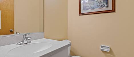 Ein Badezimmer mit Waschbecken, Spiegel und Toilette.