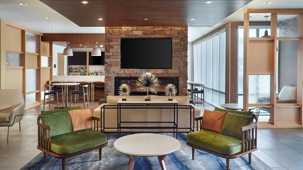 Una sala de estar moderna con chimenea, una zona de bar y un conjunto de asientos.