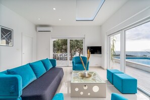Uma sala de estar moderna com sofá, poltronas e mesa de centro.