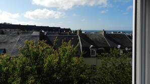 A view of rooftops with a clear sky and distant sea. - The blue house (Fécamp)