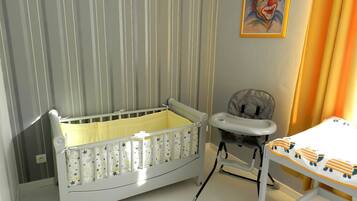 Cozy space for little ones features a crib, high chair, and playful artwork.