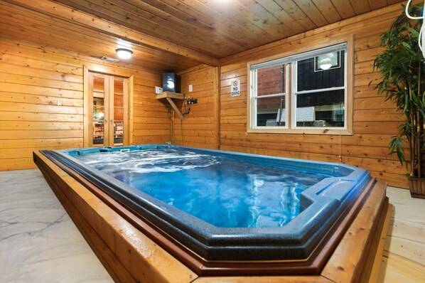 Un jacuzzi en una cabaña de madera con ventana y un cartel que indica prohibido bucear.