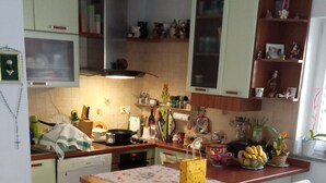 A compact kitchen with a central island, white cabinets, and a dining area with a table and chairs.