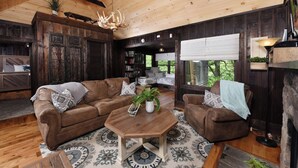 A cozy living room with a brown leather sectional sofa, a wooden coffee table, and a fireplace.
