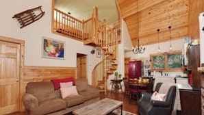 Un interior de madera con una escalera, un comedor y una cocina.