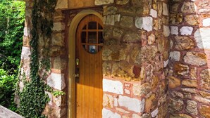 Un edificio de piedra con puerta de madera y una ventana pequeña.