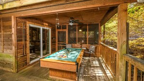 A wooden deck with a pool table and a ceiling fan. - Mountain Blessing - Relax on the Screened Porch (Sevierville)