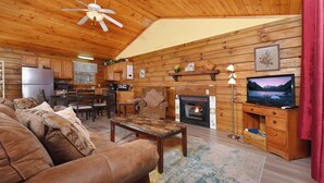 A cozy cabin interior with a living room, dining area, and kitchen.