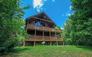Surrounded by lush greenery, this cabin offers a secluded retreat with a balcony overlooking the surrounding trees.