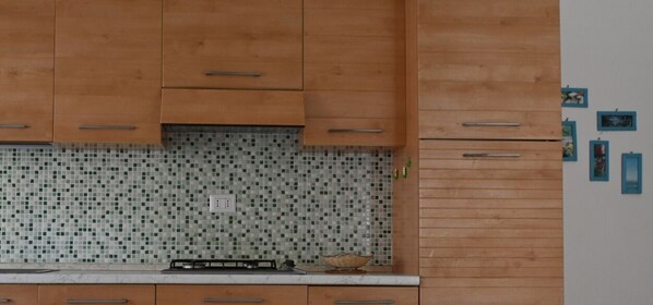 A kitchen with wooden cabinets, a tiled backsplash, and a white refrigerator. - RS320 - Marcelli, two-room apartment in seafront residence (Marcelli)