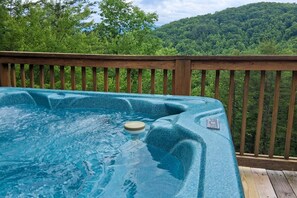 Ein Whirlpool auf einer Holterrasse mit Blick auf einen Wald.