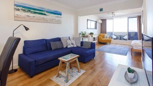 Un soggiorno moderno con un divano blu, un tavolino in legno e una poltrona gialla.