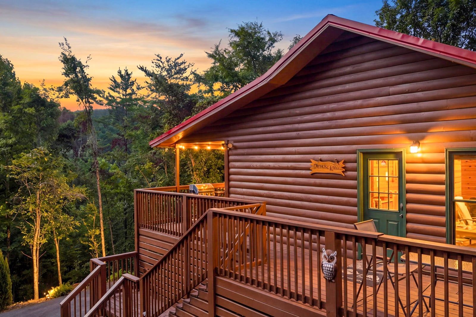 A log cabin with a porch, a staircase, and a sign that reads 'Domaine Koko'.