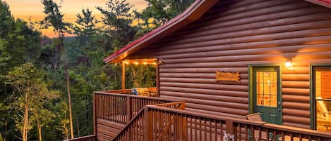 A log cabin with a porch, a staircase, and a sign that reads 'Domaine Koko'.