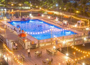 A pool area with a wooden deck, lounge chairs, and tables. - Apartamento familiar en Sun Rise San Andrés (San Andrés)