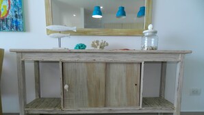 A rustic wooden console table with a mirror above it, a small shelf, and decorative items. - Lujoso Apartamento Frente al Mar (Coveñas)