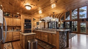 Un'ampia cucina con mobili in legno, piani di lavoro in granito e una grande isola.