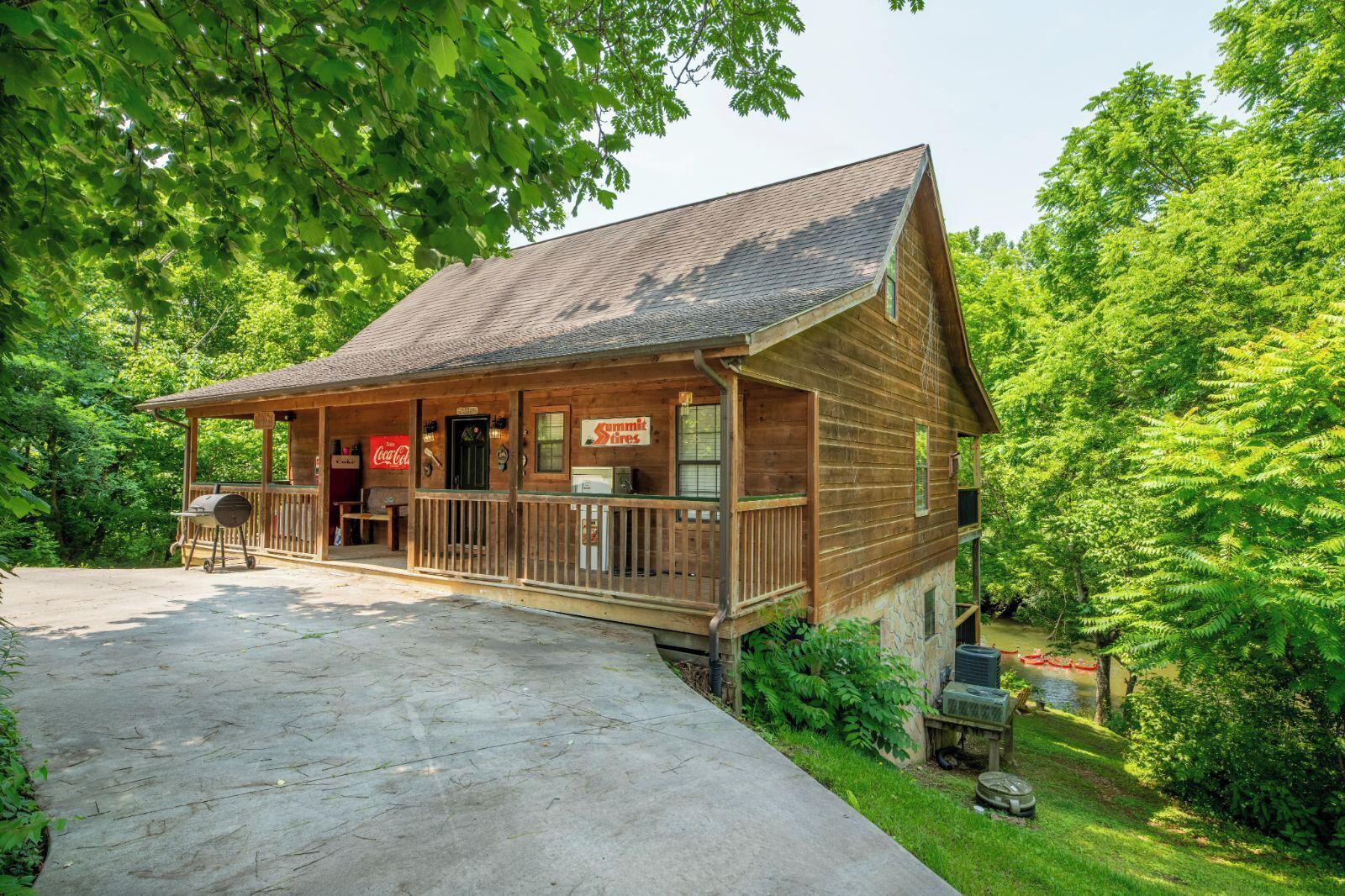 A wooden cabin with a porch, a Coca-Cola sign, and a sign for Summit Tires.