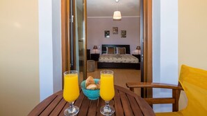A hotel room with a bed, bedside tables, a ceiling light, and a view into the room. - Louisa's Summer House (Corfu)