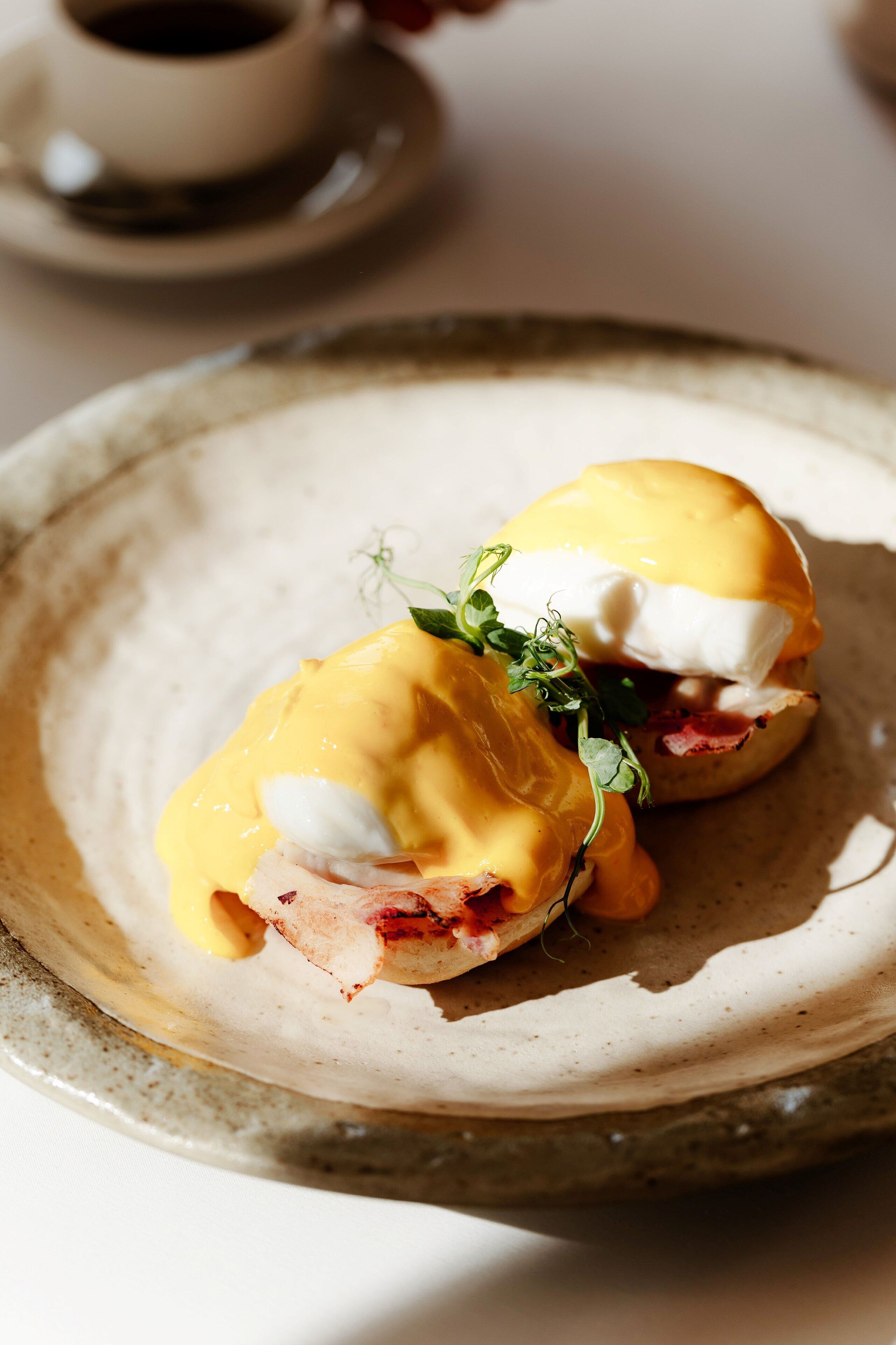 A breakfast dish with eggs and ham on a ceramic plate.