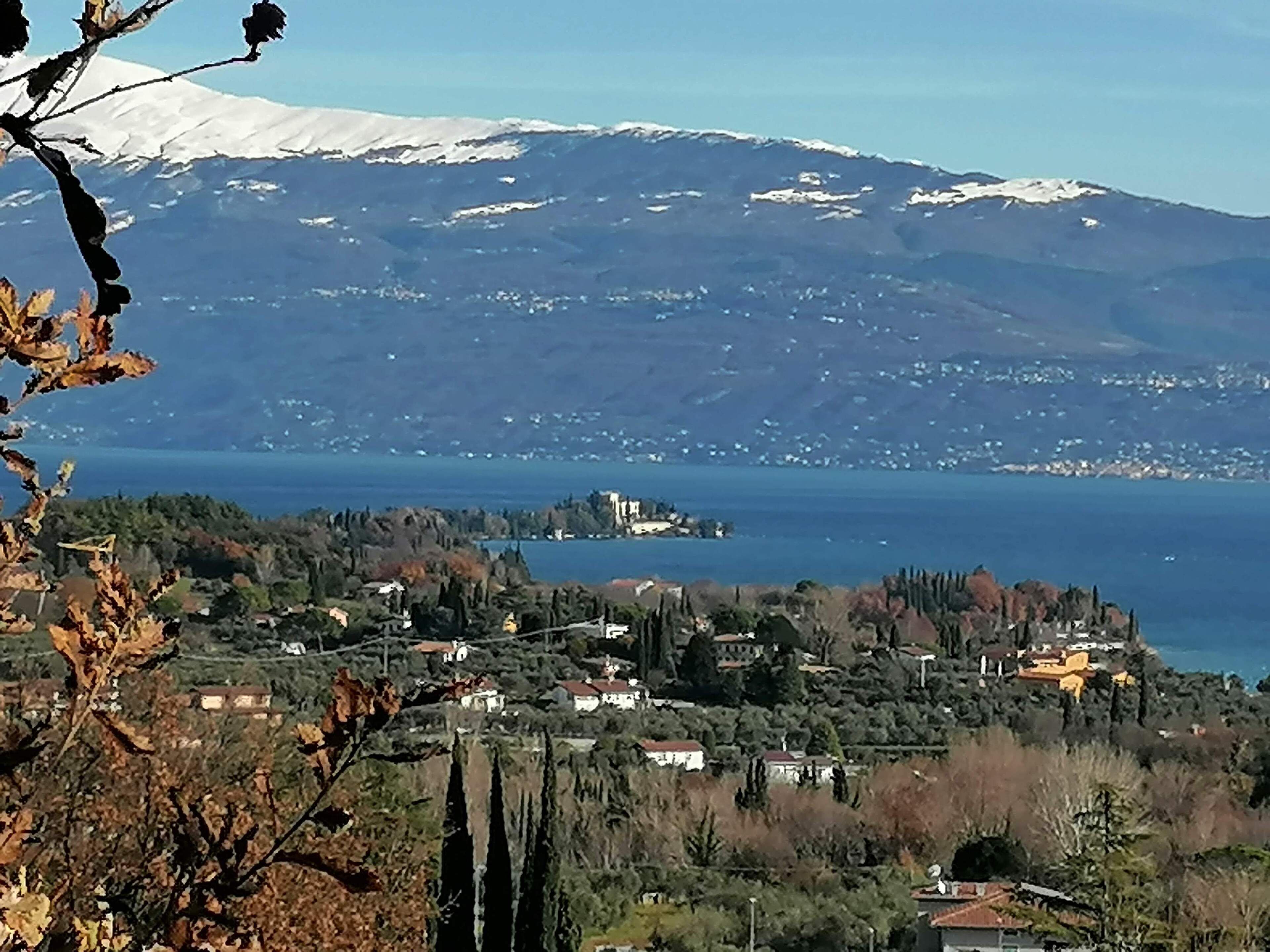 Une ville côtière avec une montagne en arrière-plan, des maisons et une étendue d’eau.