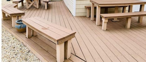 Enjoy outdoor dining or relaxation on the deck with comfortable benches and tables.