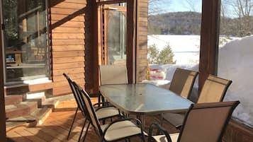 Enjoy a serene view from the deck with a glass-enclosed table and chairs.