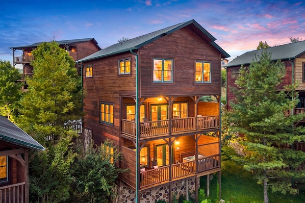 A multi-story wooden building with balconies and large windows, surrounded by trees. - Morning Glory - Incredible Mountain Views・Private Hot Tub, Theater, Pool Table, and Arcade! + (Gatlinburg)