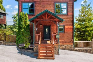 Eine Holzhütte mit Veranda, einer Haustür und einem Briefkasten.