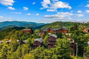 Ein Bergresort mit mehreren Holzhütten, umgeben von üppiger Vegetation und Bergen im Hintergrund.
