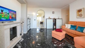 A living room with a flat-screen TV, a fireplace, a sofa, and a coffee table. - DesenzanoLoft Ciao Lago  (Desenzano del Garda)