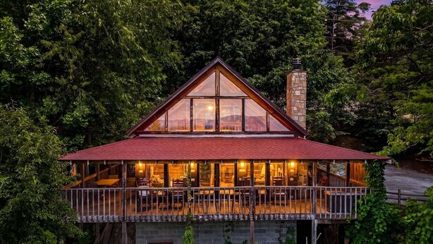 A two-story house with a balcony, surrounded by dense trees. - Peak A View - Spectacular Mountain View, Rec Room Loft, Relaxing Hot Tub (Sevierville)