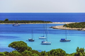 A coastal scene with several sailboats anchored in clear blue waters, surrounded by lush greenery and a sandy beach in the background. - Apartment in Luka with Seaview, Terrace, Air condition, WIFI (4659-1) (Luka)