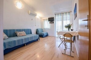 Cozy space with a sofa, dining table, and TV, perfect for relaxing.