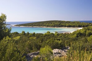 Escape to a serene coastal haven with breathtaking views of the turquoise sea and sandy beach.