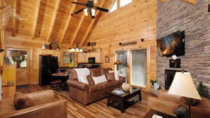 A cozy log cabin interior with a living room, kitchen, and dining area. - Ever After - Community Pool, Spa Tub, Pool Table, Hot Tub, & Smart TV! (Sevierville)