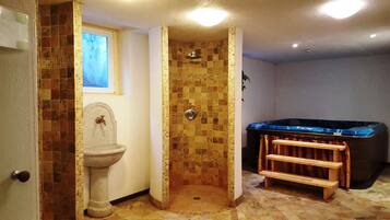 Bathroom features a bathtub, pedestal sink, and mosaic tile walls.
