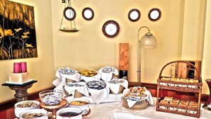A buffet setup with various food items and a painting on the wall. - Orovacanze Hotel Villa Emma (Canazei)