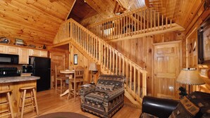 A log cabin interior with a kitchen, dining area, and living room. - Think a Little Less - Air Hockey, Gas Fireplace (Sevierville)