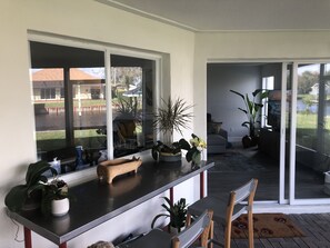 Enjoy a spacious living area with a kitchen, sliding glass doors, and a view of the outdoor lawn.