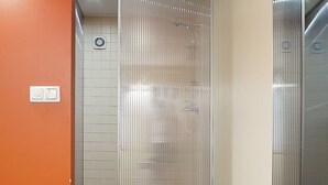 Un ascenseur moderne avec une finition métallique et un panneau en verre.