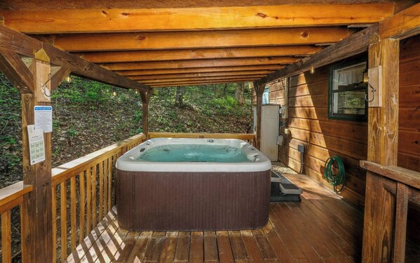 Relax in the hot tub on this deck with a pergola overhead.